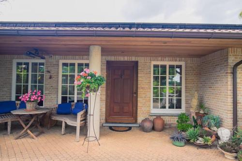 a brick house with a wooden door and a patio at Countryside - Experience in Koewacht