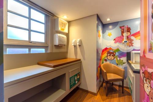a kids room with a desk and a window at Hotel Laghetto Gramado in Gramado