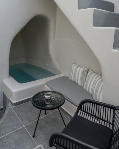 a tub in a room with a bench and a table at Alaya Suites in Pirgos