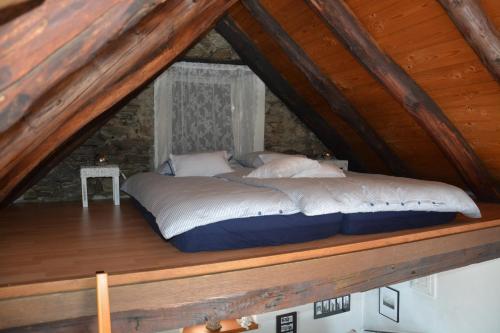 ロカルノにあるCasa don Boscoの屋根裏の木製の台に座るベッド