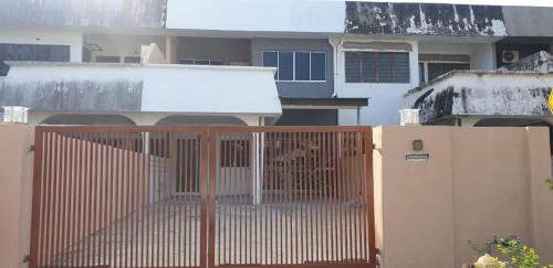 a fence in front of a house with a building at AL Cozy Seri Kuantan Home in Kuantan