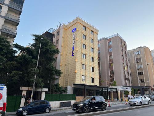een hoog gebouw met auto's geparkeerd voor het bij Istanblu Hotel Ataşehir in Istanbul