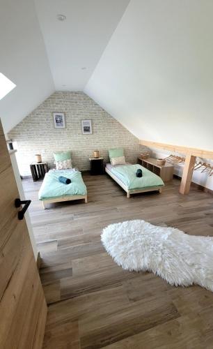 a attic room with two beds and a rug at Maison La Bonbonnière chaleureuse avec parking et garage gratuit proche frontière in Forstfeld