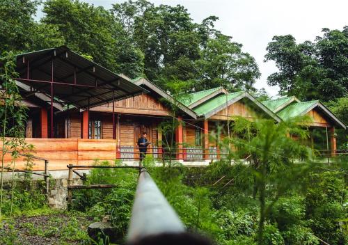 a man standing in front of a wooden house at Camp David, Kigwema in Kohīma