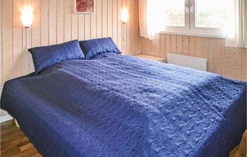 een blauw bed met een blauw dekbed in een slaapkamer bij Beautiful Home In Oksbl With Wifi in Oksbøl