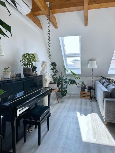 a living room with a piano and a couch at SKYLINE Penthouse Apartment - Luxus & Zentral in Braunschweig