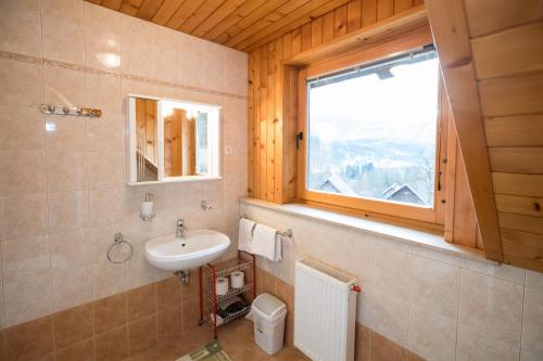 baño con lavabo y ventana en Turistična kmetija Pri Andreju en Bohinj