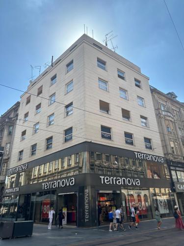 um grande edifício com pessoas andando na frente dele em B&B Cvjetni em Zagreb