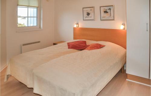 Lønne HedeにあるAmazing Home In Nrre Nebel With Indoor Swimming Poolのベッドルーム(白い大型ベッド1台、木製ヘッドボード付)