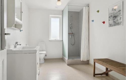 Baño blanco con lavabo y aseo en Beautiful Home In rum Djurs With Kitchen, en Nimtofte