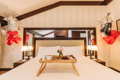 a bed with a tray of food and balloons at Palazzo Bezzi Hotel in Ravenna