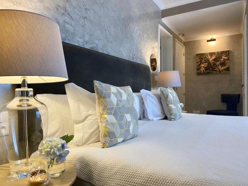 een slaapkamer met een bed met kussens en een lamp bij Quinta dos Bravos in Pico da Pedra
