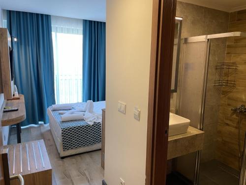 a bathroom with a shower and a sink and a tub at KAYA GARDEN OTEL in Side