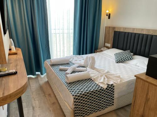 a bedroom with a bed with towels on it at KAYA GARDEN OTEL in Side