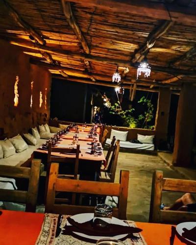 a long dining room with long tables and chairs at Maison Boutchrafine in Erfoud