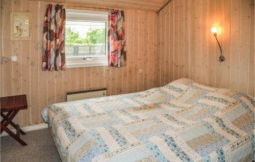 a bedroom with a bed with a quilt on it at Awesome Home In Oksbl With 3 Bedrooms And Wifi in Ovtrup