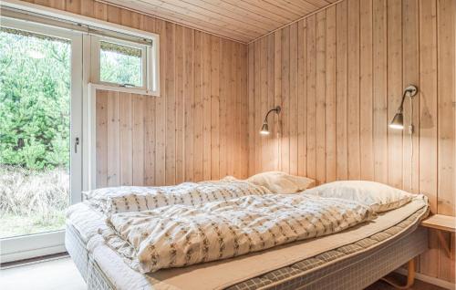 ブラーバンドにあるAwesome Home In Blvand With 4 Bedrooms, Sauna And Wifiの窓のある木製の壁のドミトリールームのベッド1台分です。