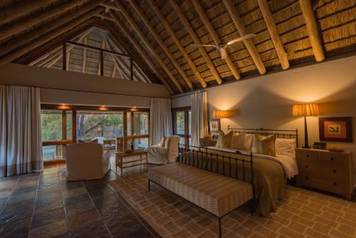 a bedroom with a bed and a living room at Simbavati River Sands in Timbavati Game Reserve
