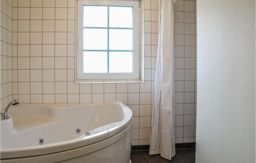 baño con bañera blanca y ventana en Awesome Home In Nrre Nebel With Indoor Swimming Pool, en Lønne Hede