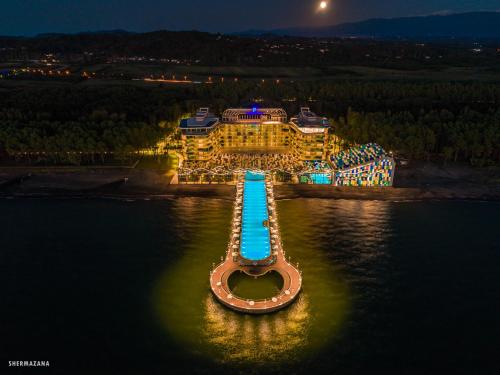 an aerial view of a resort in the water at night at Paragraph Resort & Spa Shekvetili, Autograph Collection in Shekhvetili