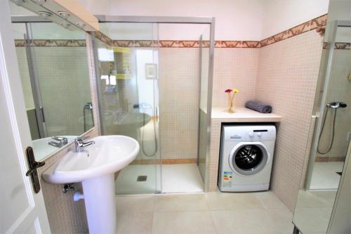 a bathroom with a sink and a washing machine at Summer Dreams Beach House in Playa Honda