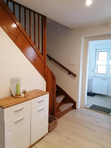 a room with a staircase with a white dresser and a stair case at Ferienhaus Rosmarie am Elbradweg in Grödel