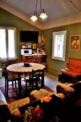 a living room with a table and a piano at Casa Fiorenza in Montefelcino