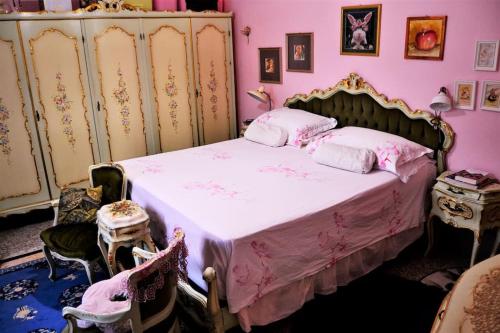 1 dormitorio con 1 cama con paredes de color rosa en Casa Fiorenza, en Montefelcino