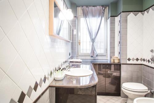 ミラノにあるMargreth Apartmentのバスルーム(洗面台、トイレ付)、窓が備わります。