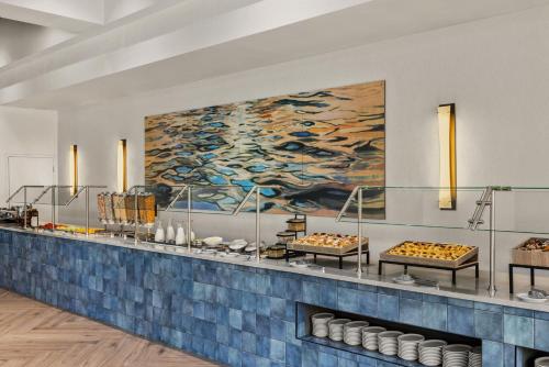 a buffet line with a painting on the wall at Delta Hotels by Marriott Orlando Celebration in Orlando