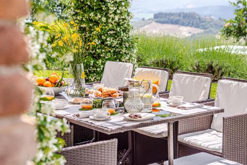 stół na świeżym powietrzu z jedzeniem i owocami w obiekcie Chateau La Siroque w mieście Montecatini Val di Cecina
