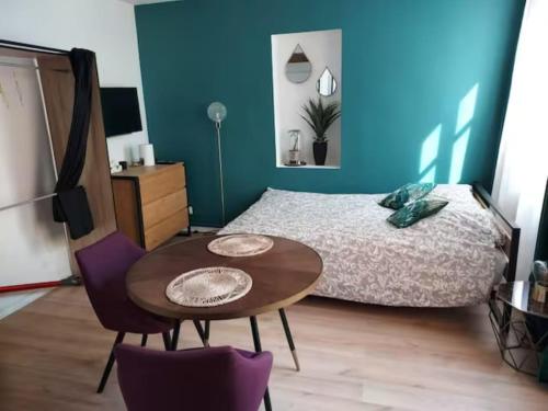 une chambre avec un lit, une table et des chaises dans l'établissement Charmant studio quartier Saint Louis à Versailles, à Versailles