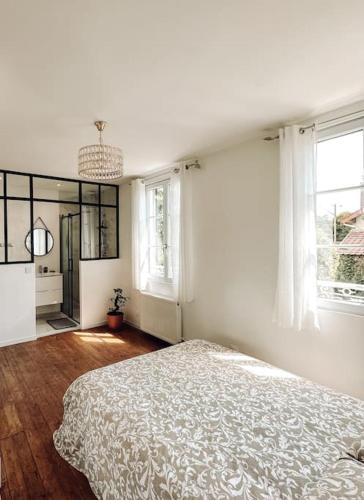 Deuil-la-BarreにあるCharmante maison de ville proche Parisの白いベッドルーム(ベッド1台、窓2つ付)