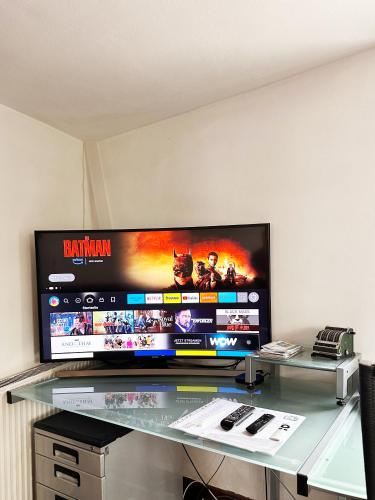 a large flat screen tv sitting on top of a glass table at Hexenhäuschen Dreieichenhain in Dreieich