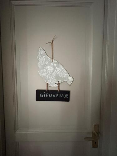 a butterfly sign on the door of a bathroom at La chambre de charme d'Edith in Auvers-sur-Oise