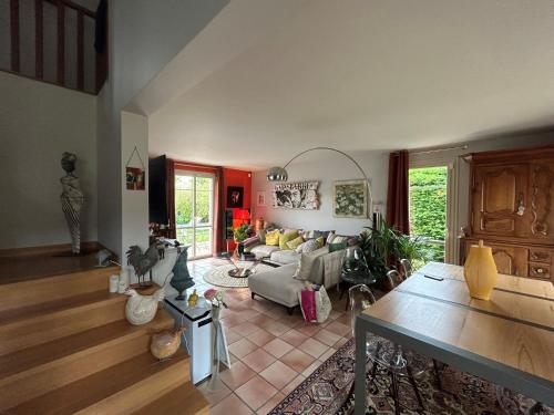 uma sala de estar com um sofá e uma mesa em La chambre de charme d'Edith em Auvers-sur-Oise