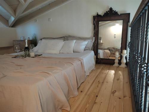 een slaapkamer met een groot bed en een spiegel bij Angel's Suites 2 in Samos