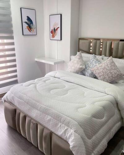 een slaapkamer met een groot wit bed in een kamer bij Apartasuite deluxe in Popayan
