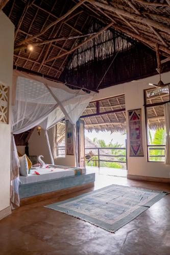 a bedroom with a bed with a mosquito net at Sunshine Marine Lodge in Matemwe