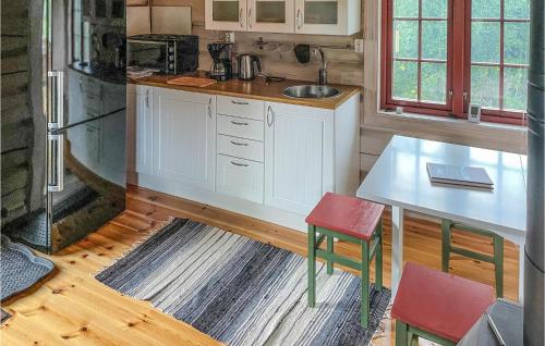 una cocina con armarios blancos, una mesa y una barra en Beautiful Home In Nord-torpa With House A Mountain View, en Nord Torpa