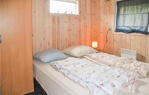 ein Schlafzimmer mit einem großen Bett an einer Holzwand in der Unterkunft Cozy Home In Oksbl With Wifi in Oksbøl