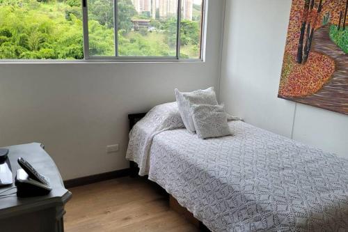 um pequeno quarto com uma cama e 2 janelas em Apartamento en Sabaneta em Sabaneta