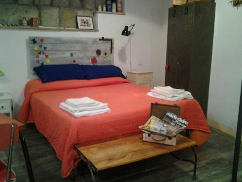 ピティリアーノにあるApartment Seminelloのベッドルーム1室(赤いシーツとテーブル付きのベッド1台付)