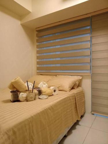 ein Schlafzimmer mit einem Bett mit einem Fenster und einigen Kissen in der Unterkunft Our Happy Place Among the Sky in Tagaytay