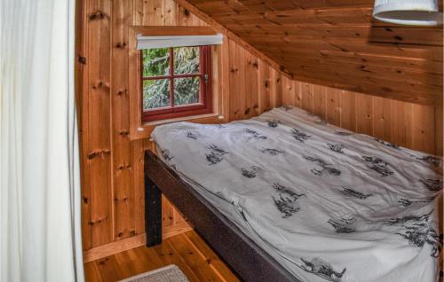 Cama en una cabaña de madera con ventana en Stunning Home In Rjukan With House A Mountain View en Rjukan