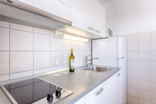 a kitchen with a sink and a bottle of wine at Adriatic Queen Residence in Split