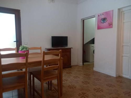 a dining room with a table and chairs and a television at Acogedor apartamento a 10min de PortAventura. in Tarragona