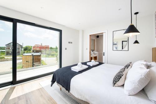 a bedroom with a white bed and a large window at Serenity WI27 - Silverlake - Dorset in Warmwell
