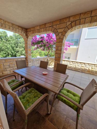 Une table et des chaises en bois sont disponibles sur la terrasse. dans l'établissement Villa Luka, à Barbariga