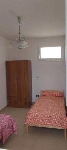 a bedroom with a bed and a dresser and a window at CASA AL MARE in Torre San Giovanni Ugento